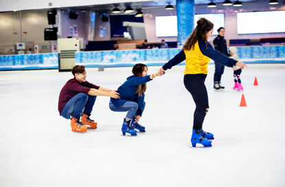 Gruppe von jugendlichen Freunden, die auf einer Eislauffläche Schlittschuh laufen